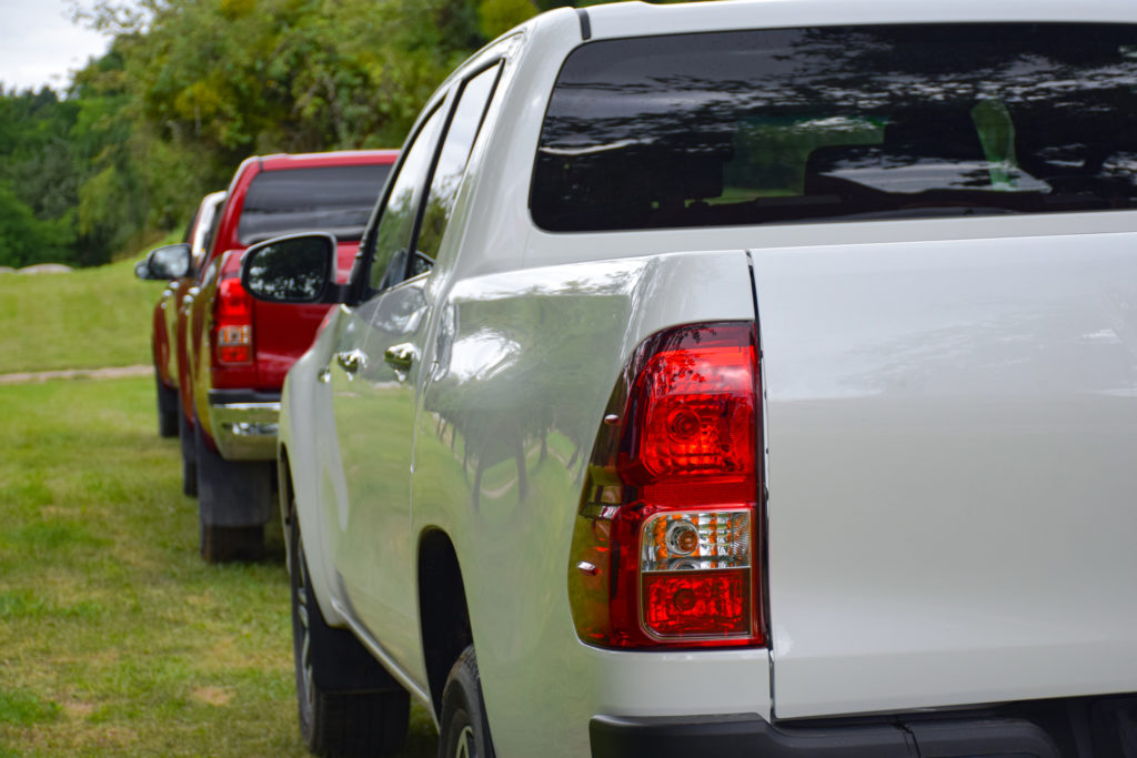 A white Toyota Hilux parked in a grassy area, representing a family business.