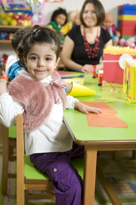 A girl providing accounting services for daycare companies while sitting at a table.