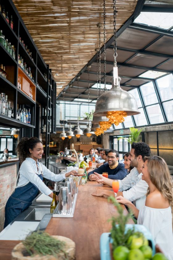 A group of people at a bar enjoying accounting services for restaurants.